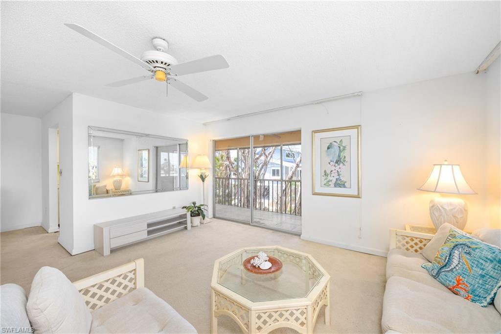 Image 3: Living room with carpet floors, a ceiling fan, and baseboards