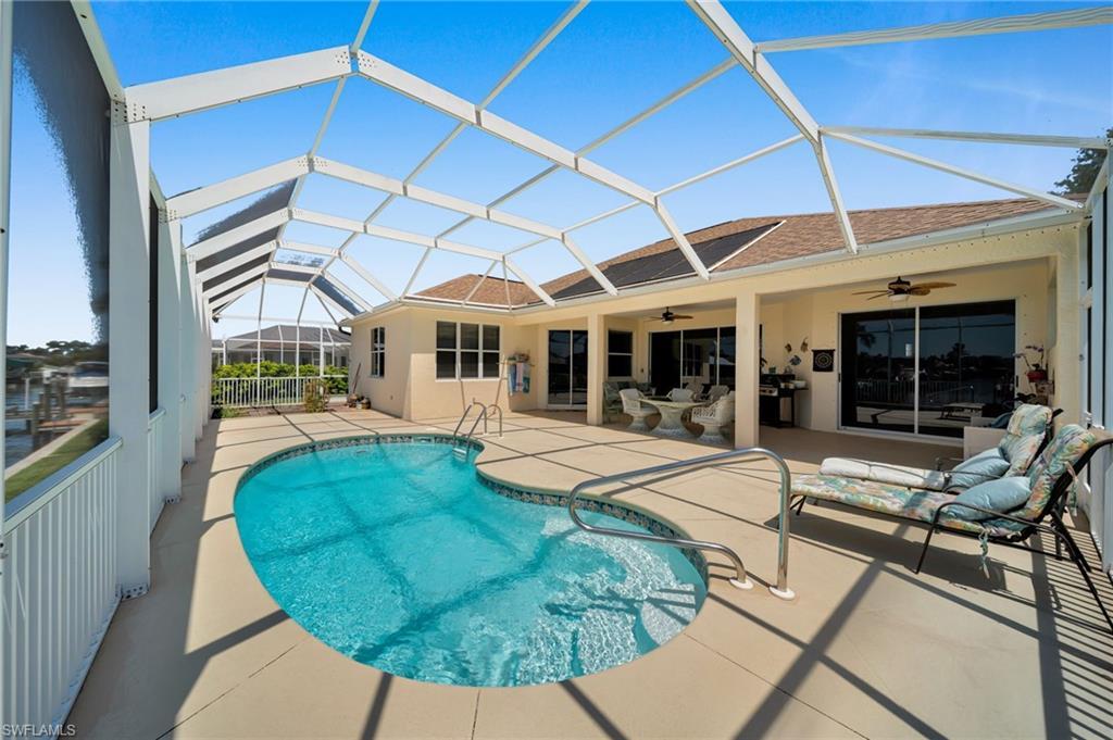 Image 3: Swimming pool featuring ceiling fan, a patio area, a lanai,outdoor lounge area, and indoor garden.