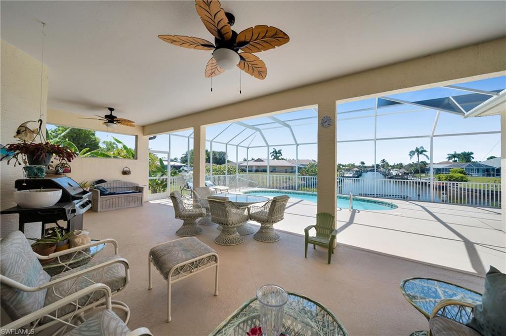 Image 4: View of patio with ceiling fan, fence, glass enclosure, and a water view
