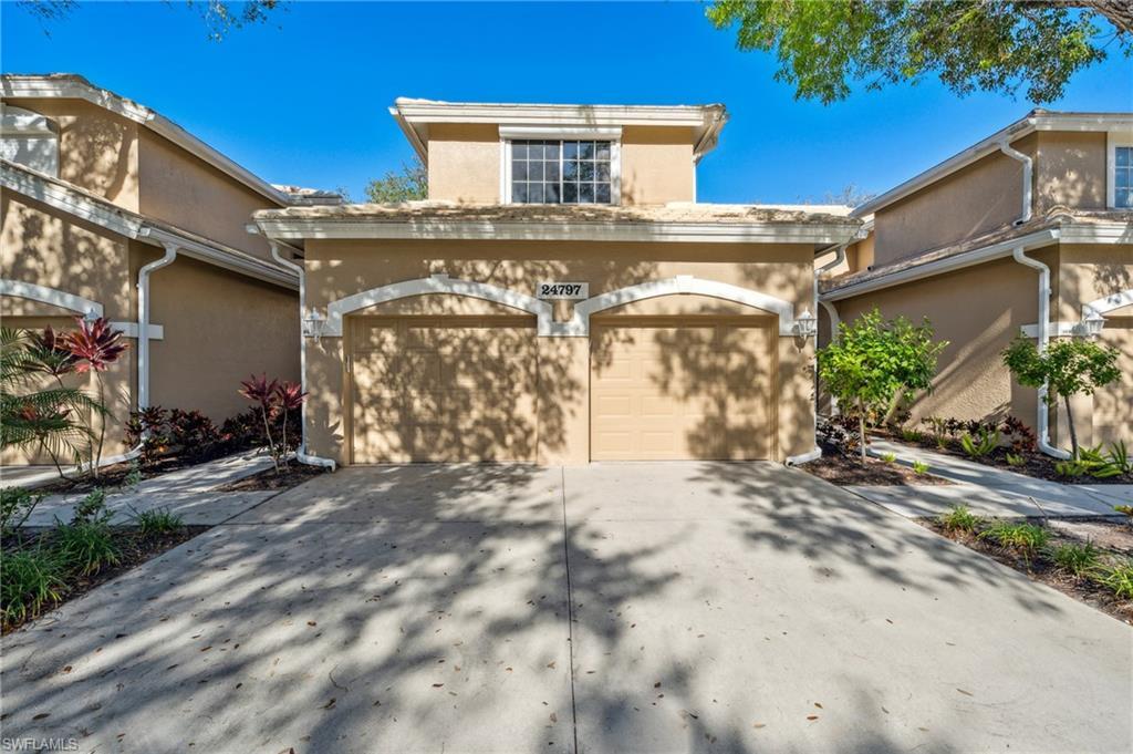 Image 2: View of front facade featuring stucco siding, a garage, and driveway