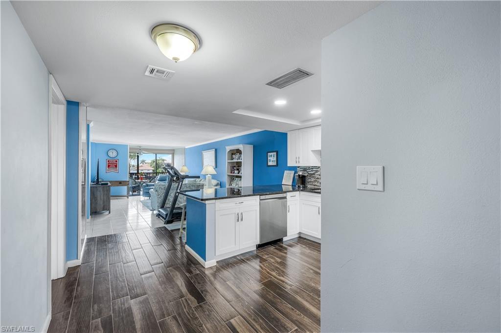 Image 2: Kitchen with dishwasher, open floor plan, a peninsula, dark countertops, and white cabinets