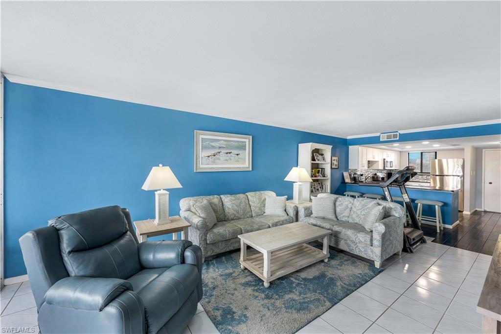 Image 3: Living room with tile patterned floors and ornamental molding