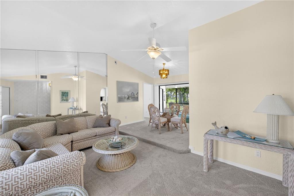 Image 2: Living area featuring a ceiling fan, carpet floors, and lofted ceiling