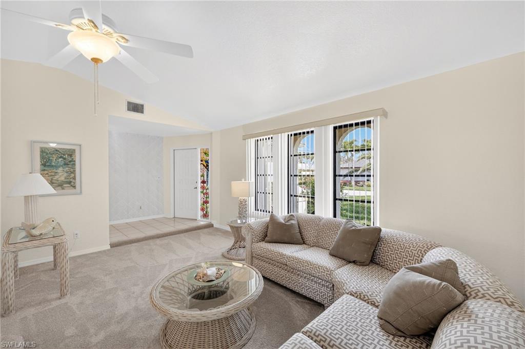 Image 4: Carpeted living room with vaulted ceiling and a ceiling fan