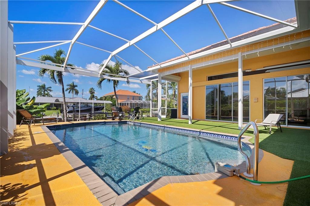 Image 1: Swimming pool with a sunroom, a lanai, a patio area, and a yard