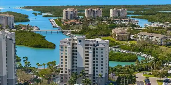 Image 2: Aerial view of apartment complex and a nearby body of water
