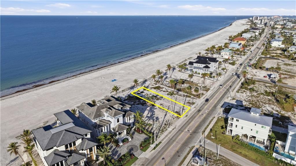 Image 1: Aerial view of residential area featuring expansive beach - Virtually Edited Image