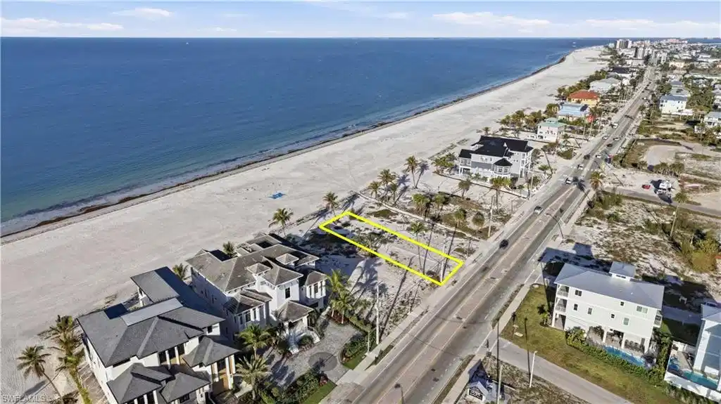 Image 1: Aerial view of residential area featuring expansive beach - Virtually Edited Image