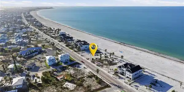 Image 2: Aerial perspective of suburban area with expansive beach - Virtually Edited Image