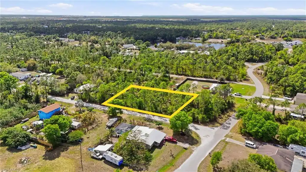Image 1: Aerial view of residential area featuring property boundaries highlighted and a heavily wooded area