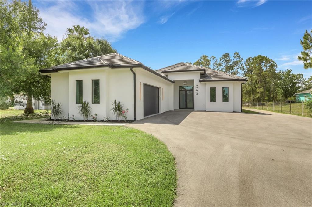 Image 3: Modern architectural exterior featuring white stucco, dark trim, and a concrete tile roof
