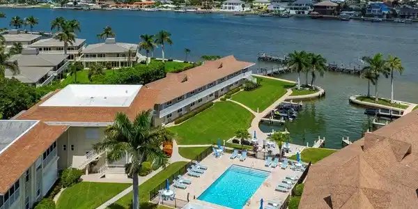Image 3: Bird's eye view of a pool area and a nearby body of water