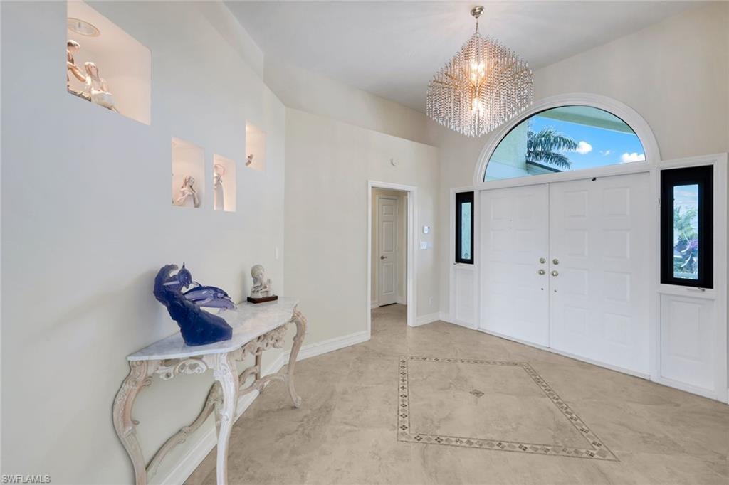 Image 3: Entryway featuring hanging lights, a high ceiling, and inlaid floor details
