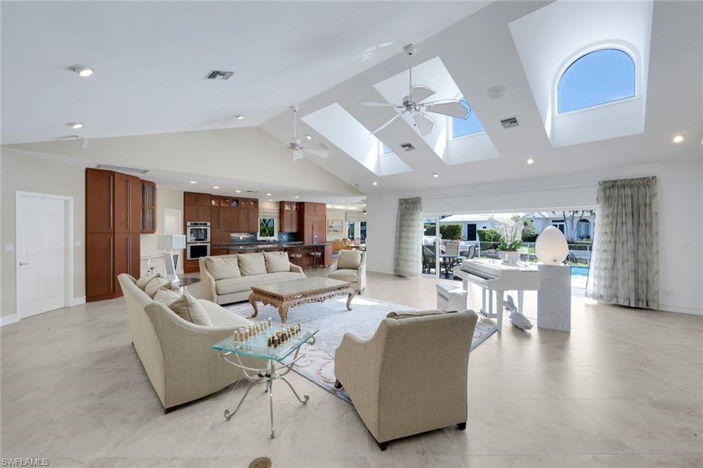 Image 4: Living room with a ceiling fan, recessed lighting, a high ceiling, and a skylight