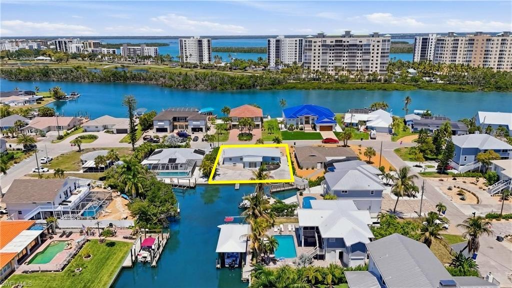 Image 1: Waterfront property featuring a private boat dock, a paved driveway, and mature landscaping - Virtually Edited Image