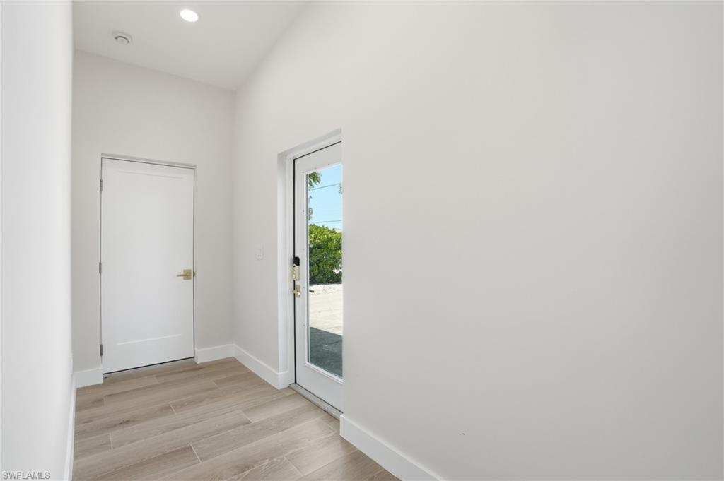 Image 2: Entryway with light-colored tile flooring, white walls, and a recessed ceiling light - Virtually Edited Image