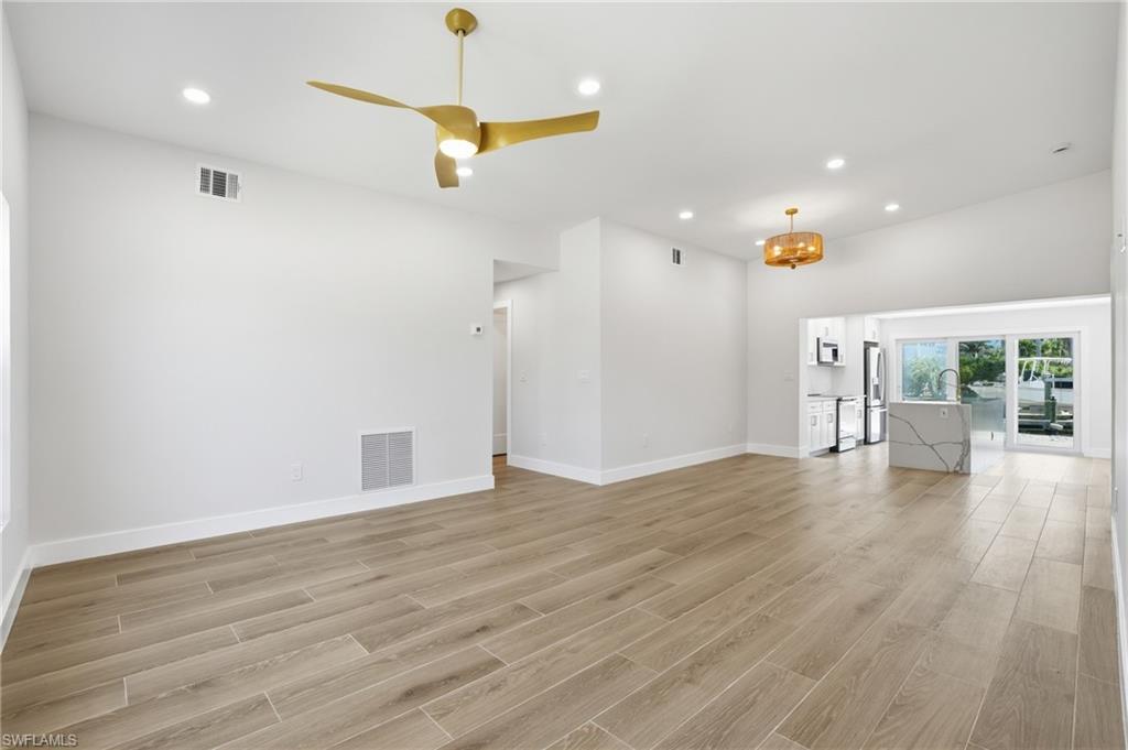 Image 4: Spacious interior featuring a contemporary ceiling fan, recessed lighting, and light-toned tile flooring - Virtually Edited Image