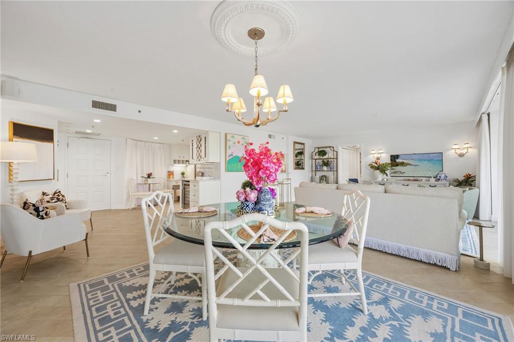 Image 4: dining area with views of kitchen and living room.