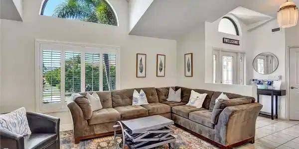 Image 3: Sun drenched living room with arched window & plantation shutters