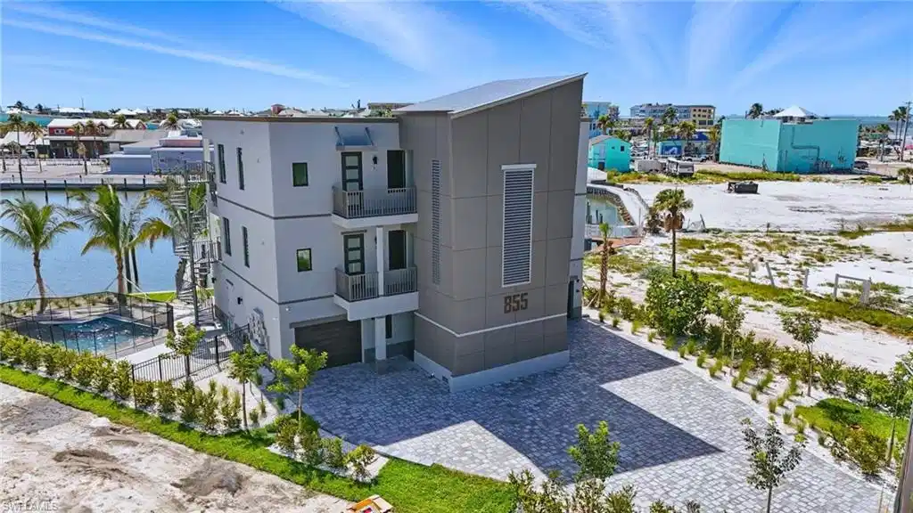Image 1: Modern multi-story property featuring a flat roofline and a two-car garage - Virtually Edited Image