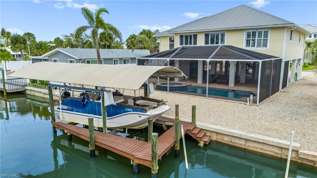Image 2: Dock area with boat lift, screened in pool and Gulf access canal - virtually enhanced