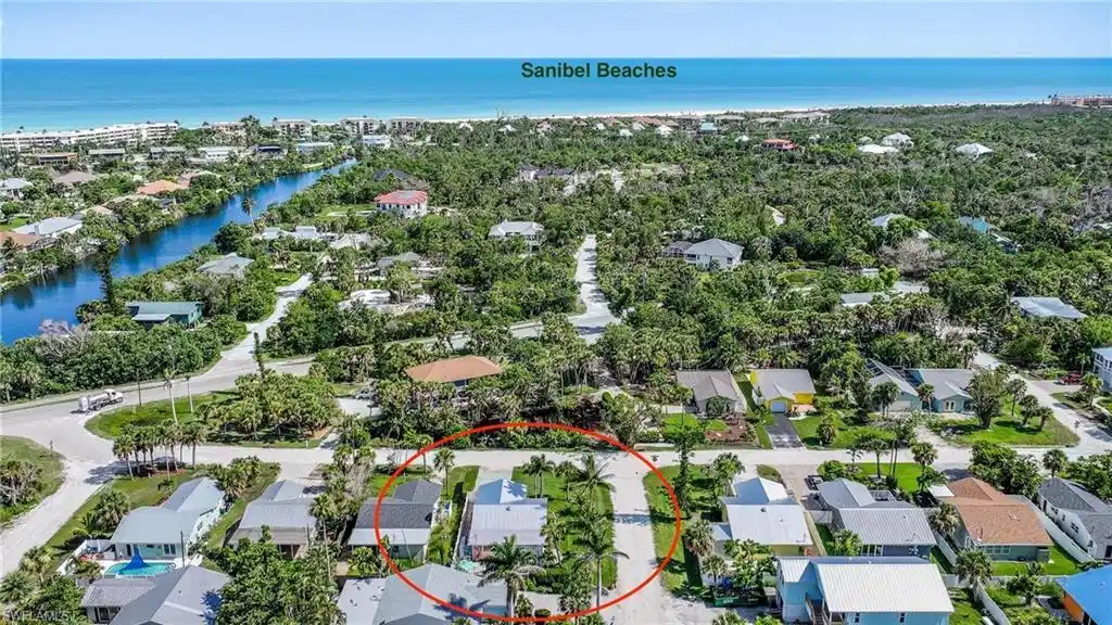 Image 1: Aerial view of residential area featuring a nearby body of water