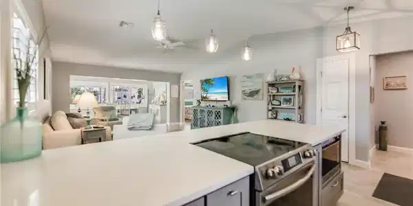 Image 3: Kitchen with appliances with stainless steel finishes, gray cabinetry, a ceiling fan, lofted ceiling, and open floor plan