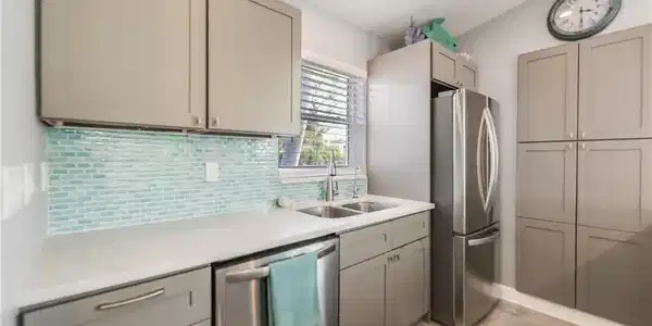 Image 4: Kitchen with appliances with stainless steel finishes, light countertops, light wood finished floors, tasteful backsplash, and gray cabinets