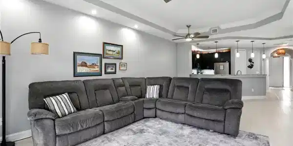 Image 2: Living area with a tray ceiling, ornamental molding, light wood finished floors, recessed lighting, and a ceiling fan