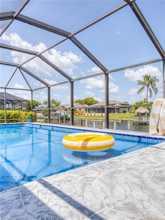 Image 3: Swimming pool with a lanai, a sunroom, a water view, and a residential view