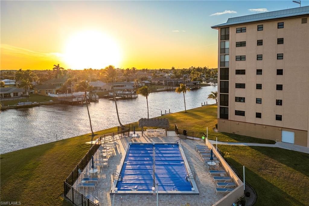 Image 2: Dock featuring a water view, a yard, and a patio area