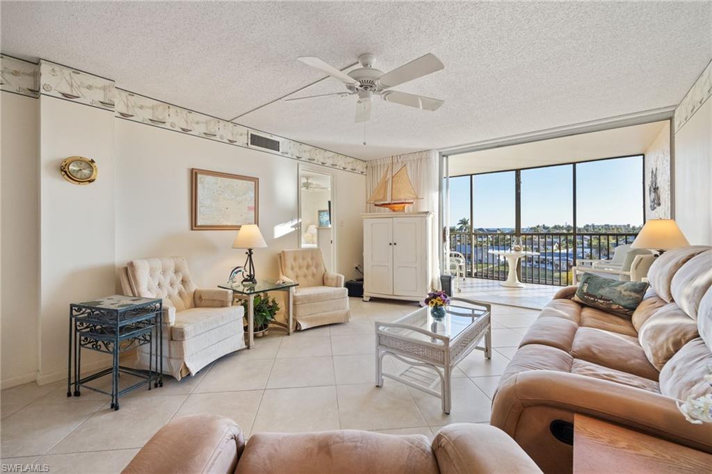 Image 4: Living area with a textured ceiling, a ceiling fan, and tile patterned flooring