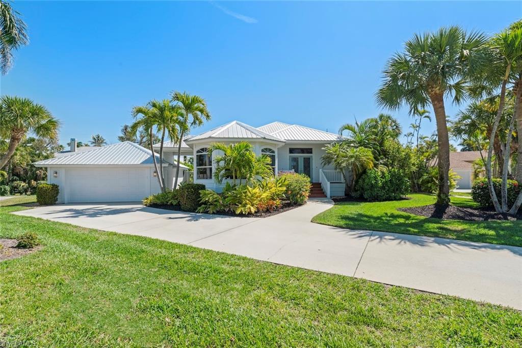Image 1: Single story home with a front yard, driveway, a garage, and a metal roof