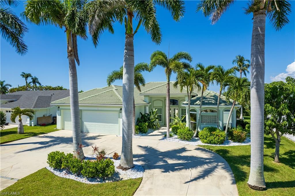 Image 1: View of front of home with an attached garage, concrete driveway, a front lawn, and stucco siding