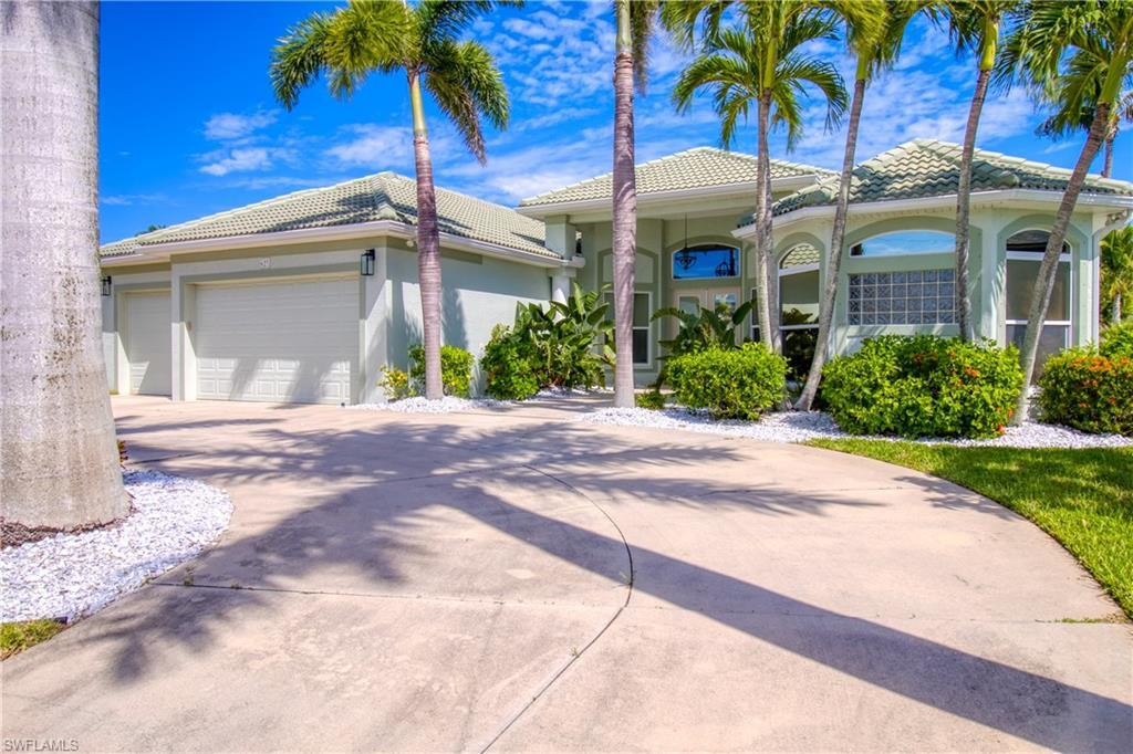 Image 2: View of front of house featuring a garage, stucco siding, concrete driveway, and a tiled roof