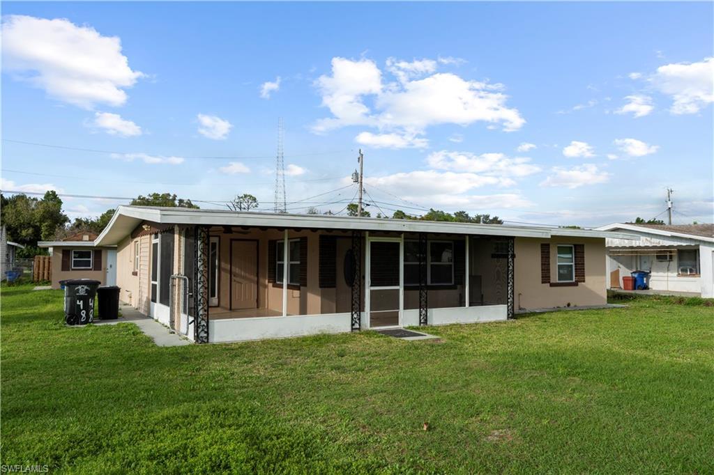 Image 3: Front of property with a sunroom and a yard