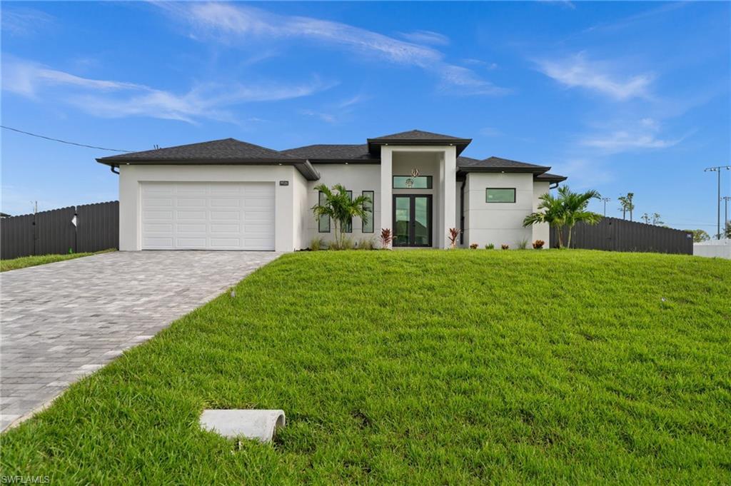 Image 2: Contemporary single-story residence with a dark shingle roof and a two-car garage