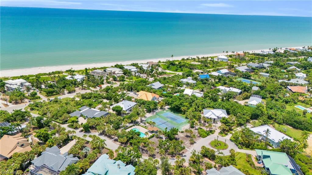 Image 3: Coastal community featuring white sand beaches, turquoise waters, lush tropical landscaping, and residential properties