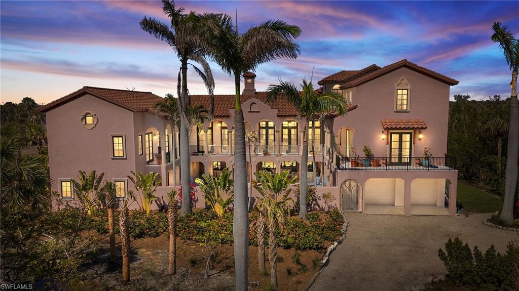 Image 1: Mediterranean / spanish home featuring a tiled roof, driveway, a balcony, stucco siding, and a patio area
