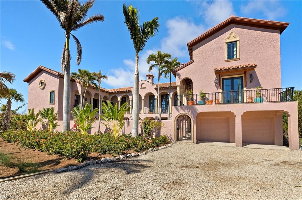 Image 2: Mediterranean / spanish home with gravel driveway, stucco siding, a balcony, french doors, and a tile roof