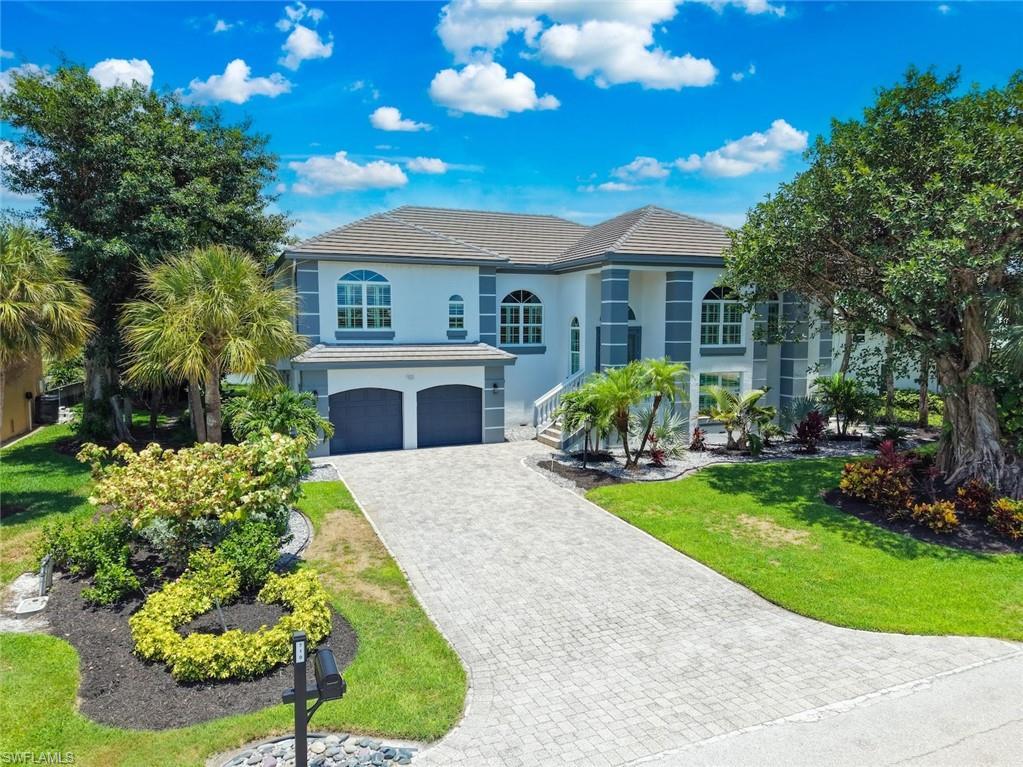 Image 1: Two-story stucco residence featuring a tile roof and two-car garage