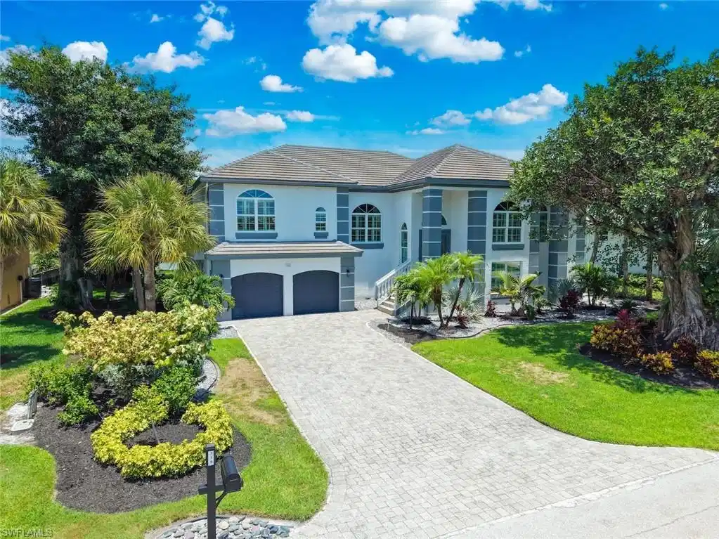 Image 1: Two-story stucco residence featuring a tile roof and two-car garage