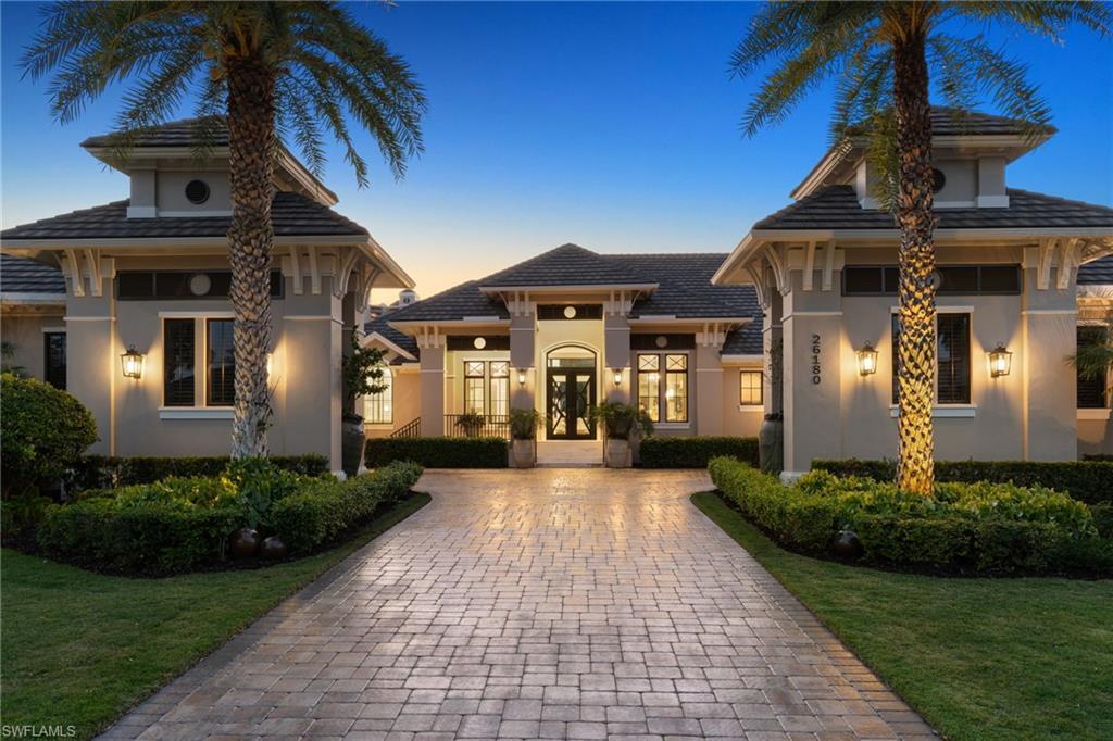Image 3: View of front facade featuring stucco siding, a lawn, decorative driveway, and french doors