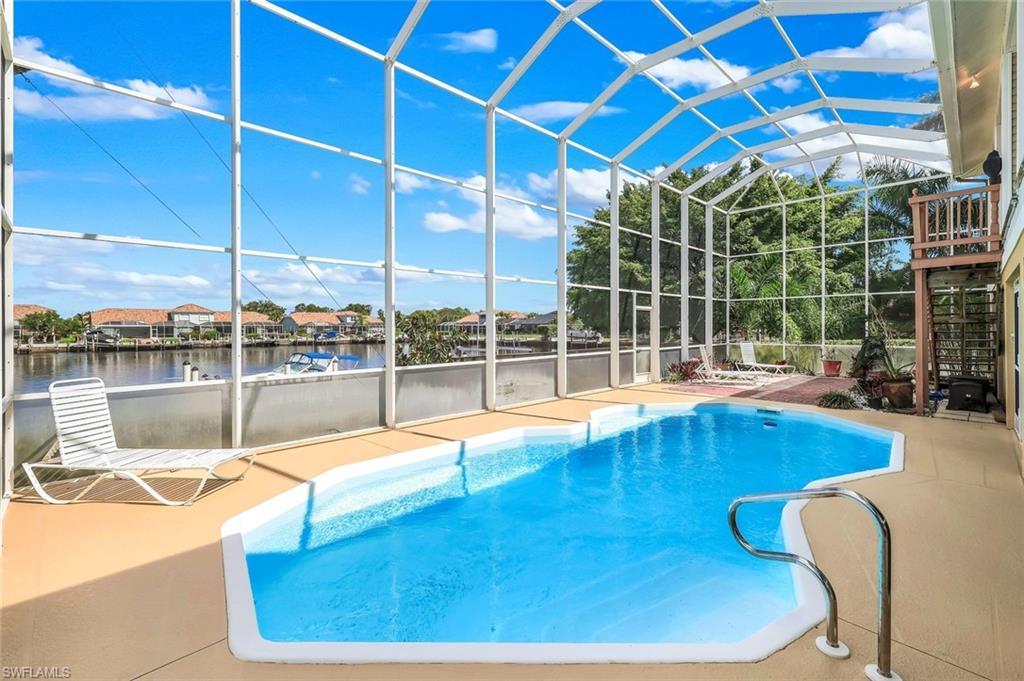 Image 2: Outdoor pool featuring a sunroom, a lanai, a patio, and a water view