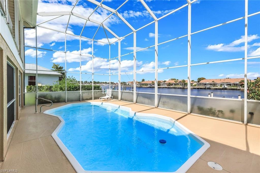 Image 3: Swimming pool with glass enclosure, a sunroom, a patio area, and a residential view