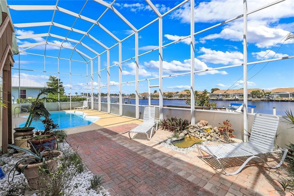 Image 4: View of pool with a lanai, a sunroom, patio surround, and a water view