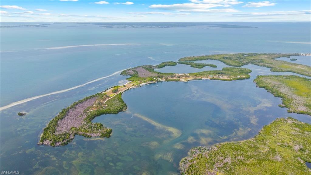 Image 1: Burgess Island Aerial view showcasing the private island's  waterfront location, surrounded by clear blue waters and lush green vegetation