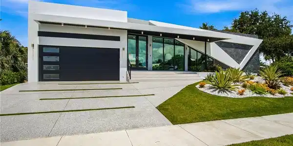 Image 2: Contemporary facade featuring a dark gray garage door with frosted window inserts