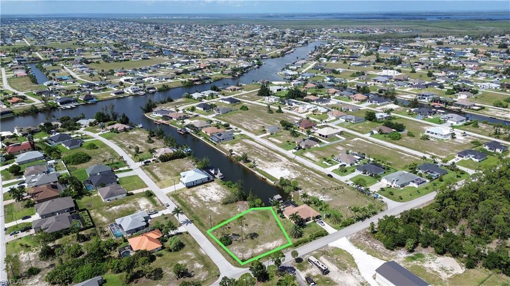 Image 3: Vacant residential lot outlined in green, situated on a street with established homes