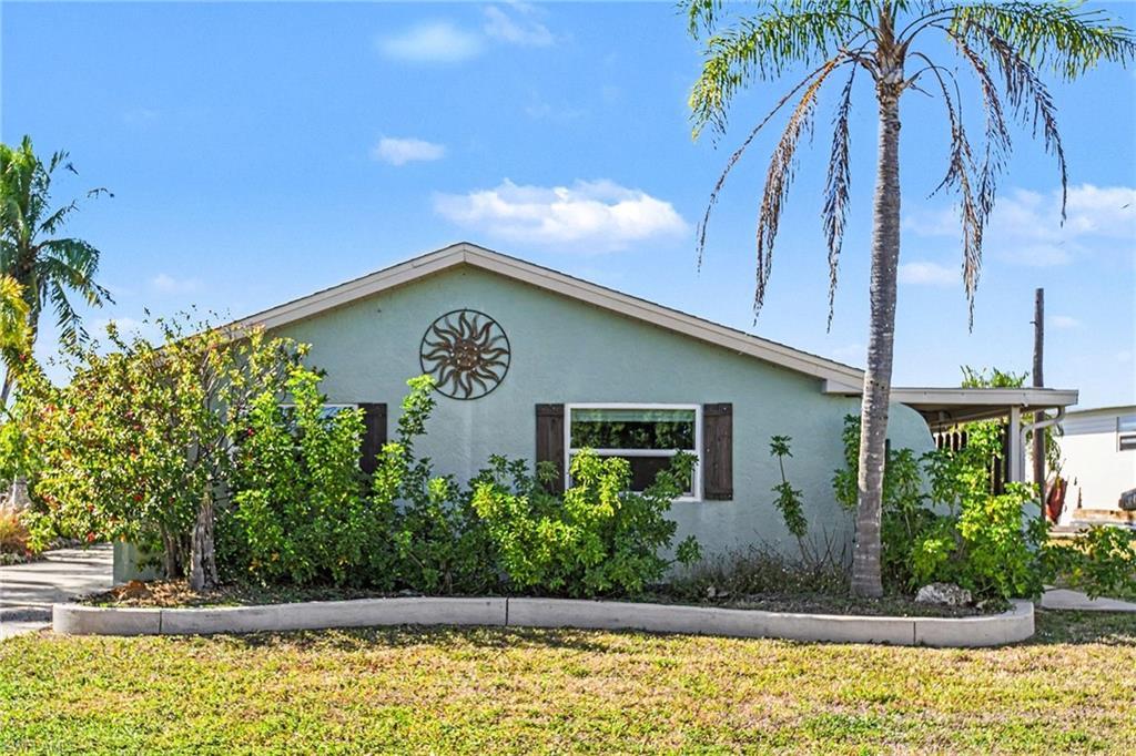 Image 2: View of side of home featuring stucco siding and a yard